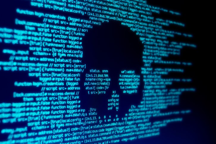 close up of malware on screen with skull shape among written code