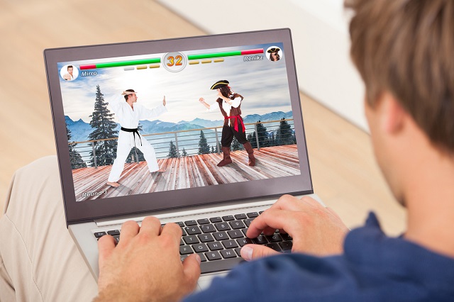 Man playing computer game on laptop