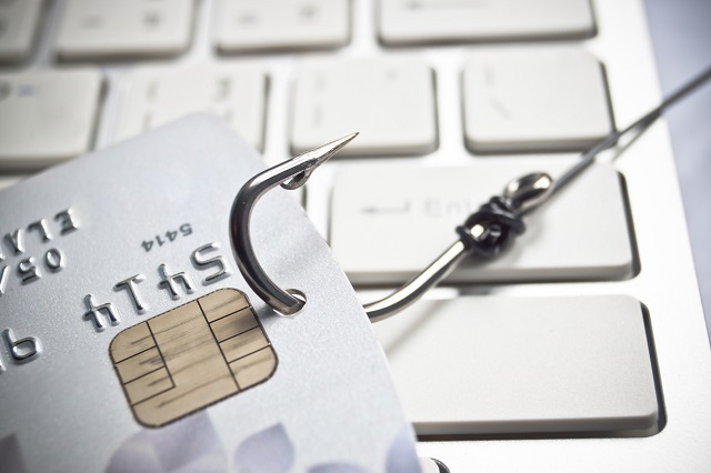 phishing - fish hook with a credit card on white computer keyboard