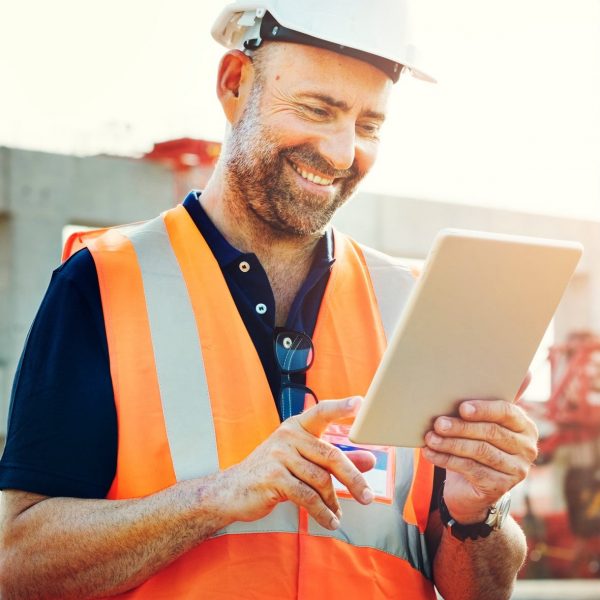 Construction worker using tablet on site for IT support and services